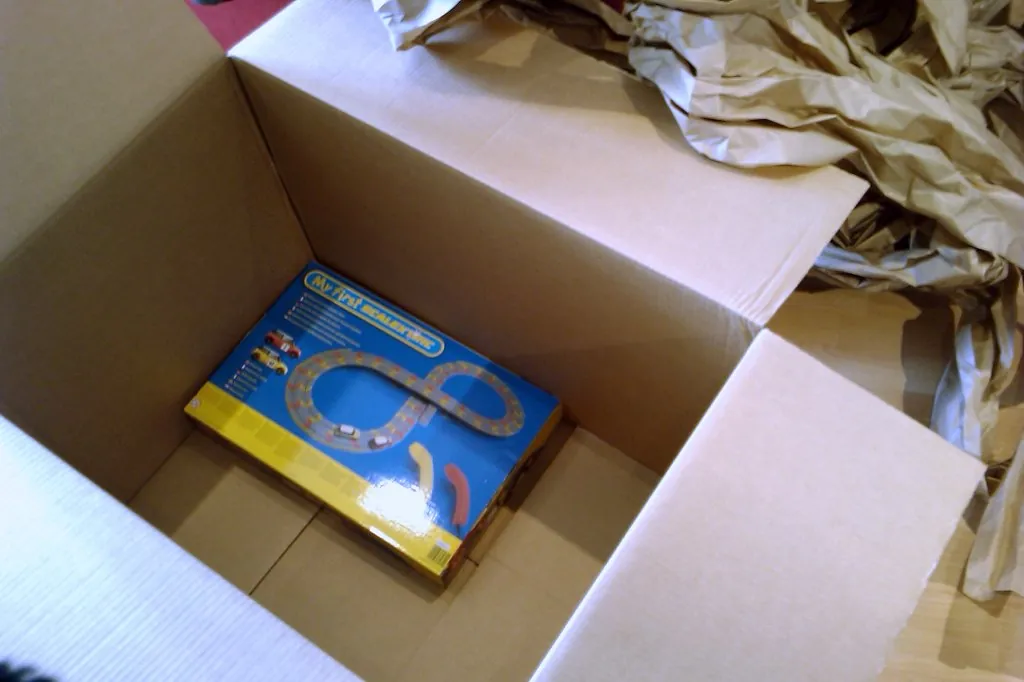 Caja de carton abierta con un producto y relleno de papel dentro