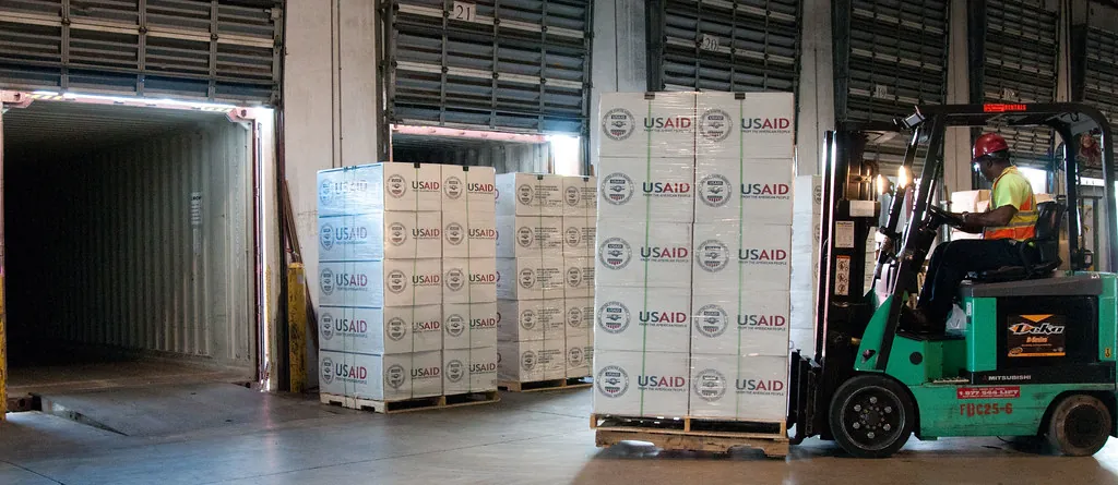 Montacargas metiendo tarimas con cajas dentro de la caja de un trailer