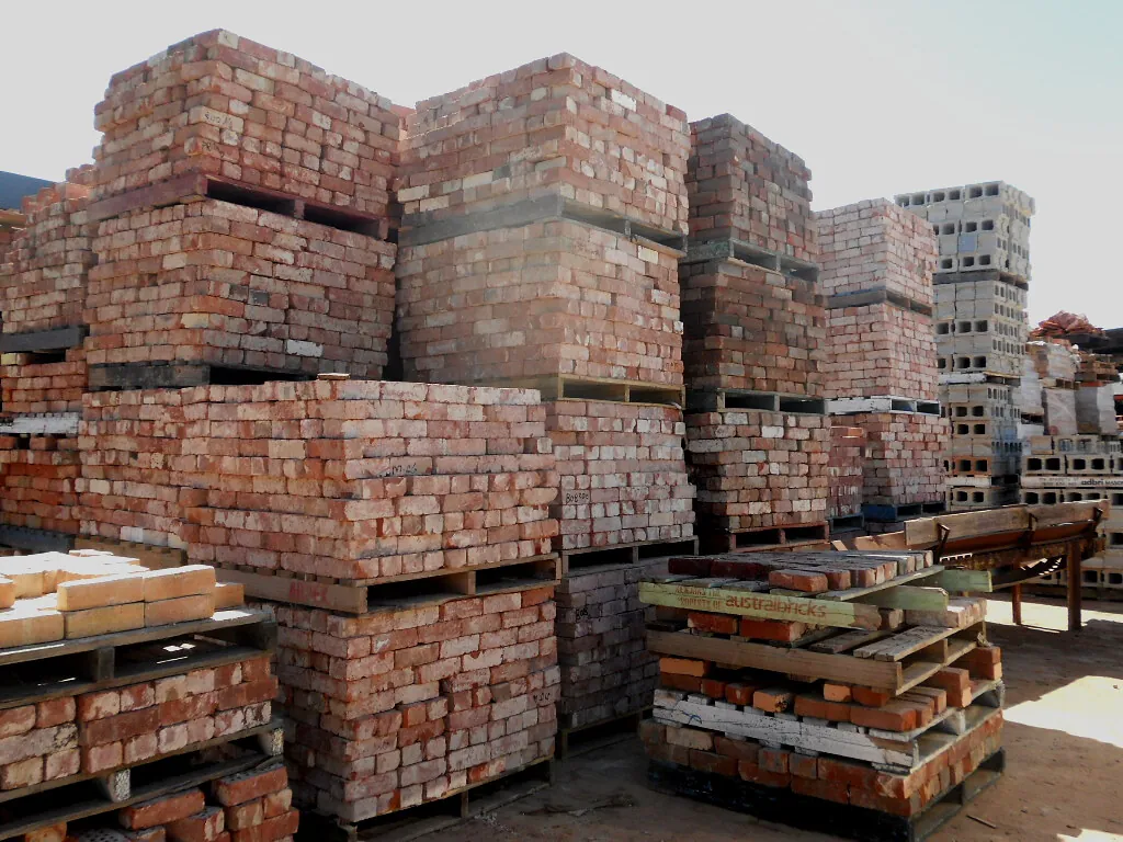 Tarimas de madera cargadas con ladrillo en un patio de materiales