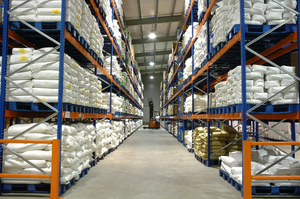 Sacos estibados sobre tarimas en un rack selectivo de almacén