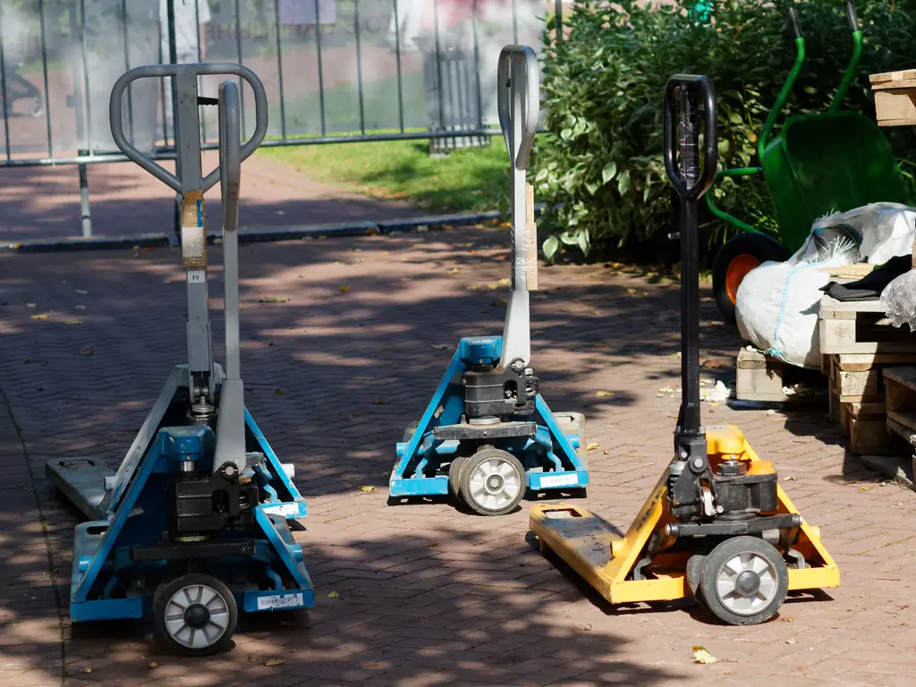Tres patines hidráulicos manuales con sus ruedas de dirección bajo la bomba